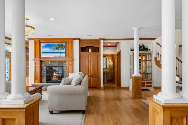 38 Captain Baker Rd, Brewster, MA 02631 - living area featuring ornate columns, light wood-style flooring, a glass covered fireplace, recessed lighting, and stairs
