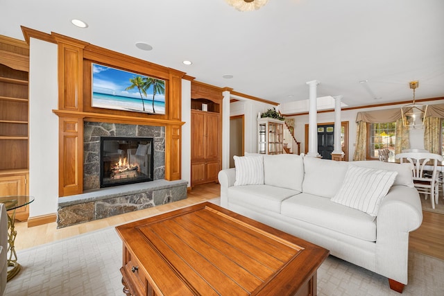 38 Captain Baker Rd, Brewster, MA 02631 - living room featuring light wood finished floors, ornate columns, a glass covered fireplace, and recessed lighting