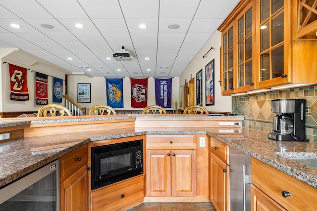 38 Captain Baker Rd, Brewster, MA 02631 - kitchen with wine cooler, black microwave, light stone countertops, brown cabinetry, and recessed lighting