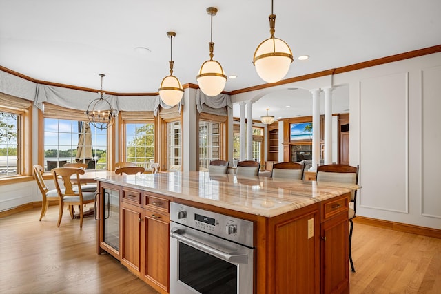 38 Captain Baker Rd, Brewster, MA 02631 - kitchen with oven, a breakfast bar, ornate columns, wine cooler, and brown cabinets