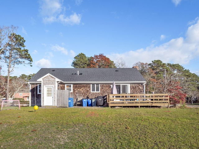 rear view of property featuring a wooden deck and a yard