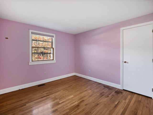 unfurnished room with hardwood / wood-style flooring