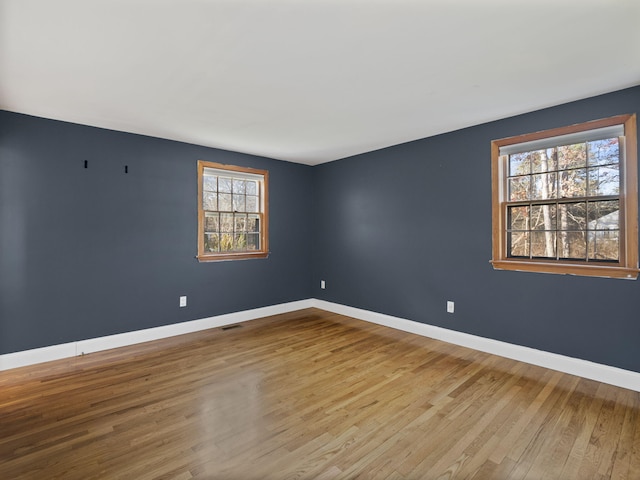 unfurnished room featuring a healthy amount of sunlight and light hardwood / wood-style floors