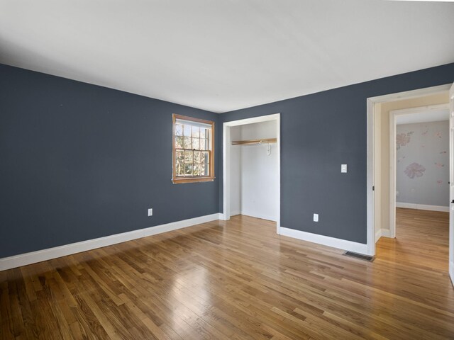 unfurnished bedroom with wood-type flooring and a closet