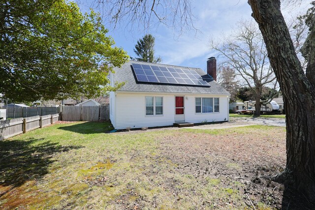 885 Sandwich Rd, Hatchville, MA 02536 - rear view of property with a yard, solar panels, a chimney, and fence