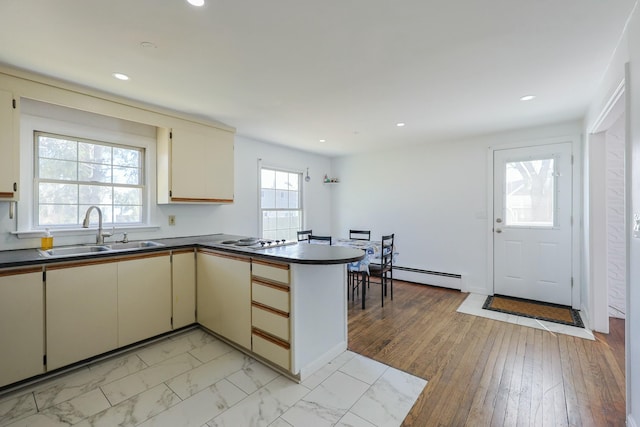 885 Sandwich Rd, Hatchville, MA 02536 - kitchen featuring dark countertops, a sink, a peninsula, baseboard heating, and cream cabinets