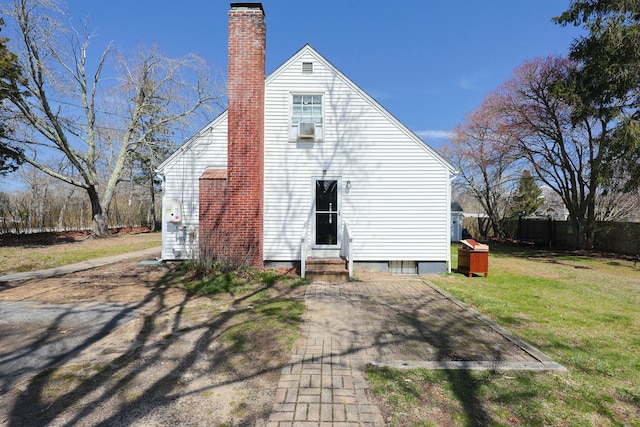 885 Sandwich Rd, Hatchville, MA 02536 - rear view of house with fence, a chimney, entry steps, and a yard