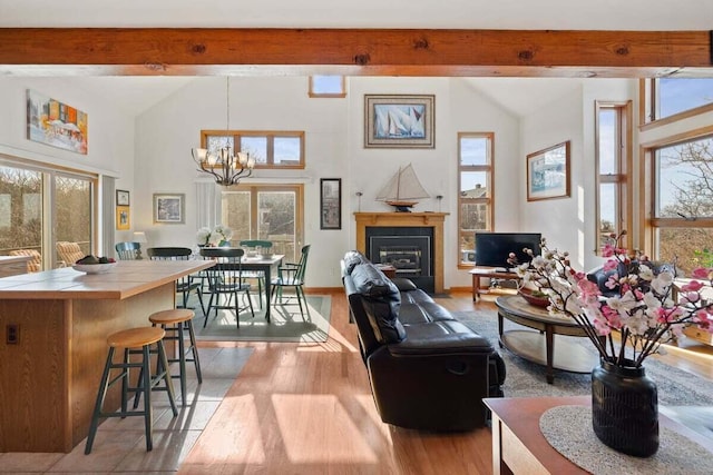 63 Swift Ln, Brewster, MA 02631 - living room featuring healthy amount of natural light, beamed ceiling, light wood-style floors, a glass covered fireplace, and high vaulted ceiling