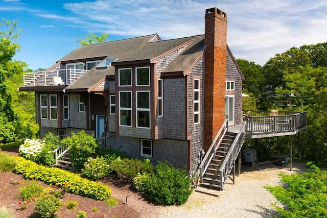 63 Swift Ln, Brewster, MA 02631 - view of front of home with stairs, a chimney, a wooden deck, and a shingled roof
