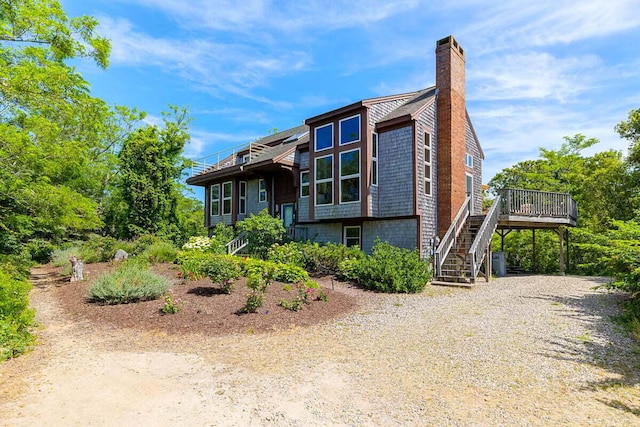 63 Swift Ln, Brewster, MA 02631 - view of front facade with stairs, a chimney, and a wooden deck