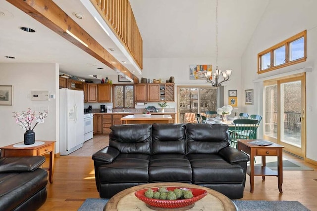 63 Swift Ln, Brewster, MA 02631 - living area with a chandelier, high vaulted ceiling, and light wood-style flooring