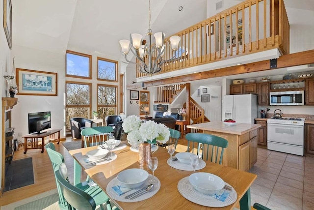 63 Swift Ln, Brewster, MA 02631 - dining area with a high ceiling, stairway, a chandelier, and light tile patterned floors