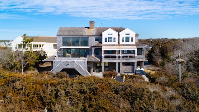 back of property featuring a chimney and stairs