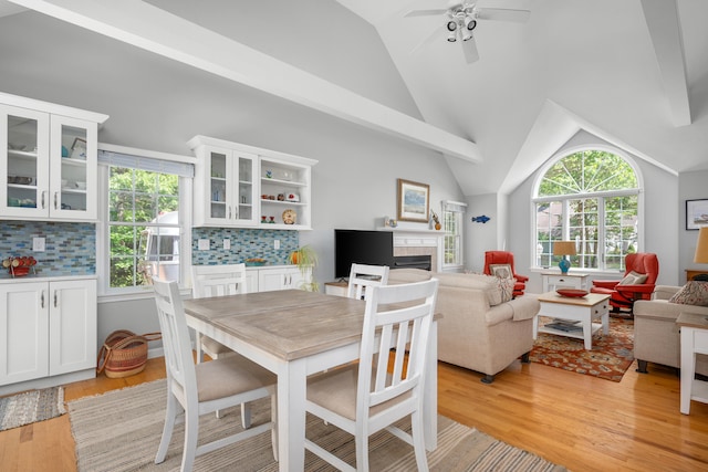 64 Manitoba Rd, Mashpee, MA 02649 - dining room with plenty of natural light, light wood-style flooring, vaulted ceiling, a tile fireplace, and a ceiling fan