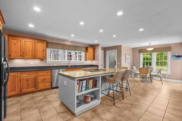 350 Plum St, West Barnstable, MA 02668 - kitchen with appliances with stainless steel finishes, a kitchen island, recessed lighting, a kitchen bar, and brown cabinets
