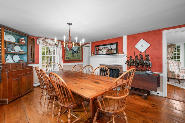 350 Plum St, West Barnstable, MA 02668 - dining area featuring hardwood / wood-style floors, healthy amount of natural light, a chandelier, and a brick fireplace