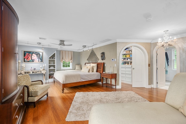 350 Plum St, West Barnstable, MA 02668 - bedroom with arched walkways, wood finished floors, ornamental molding, a ceiling fan, and a chandelier