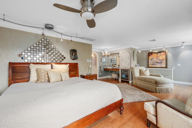 350 Plum St, West Barnstable, MA 02668 - bedroom featuring rail lighting, wood finished floors, crown molding, a ceiling fan, and a chandelier