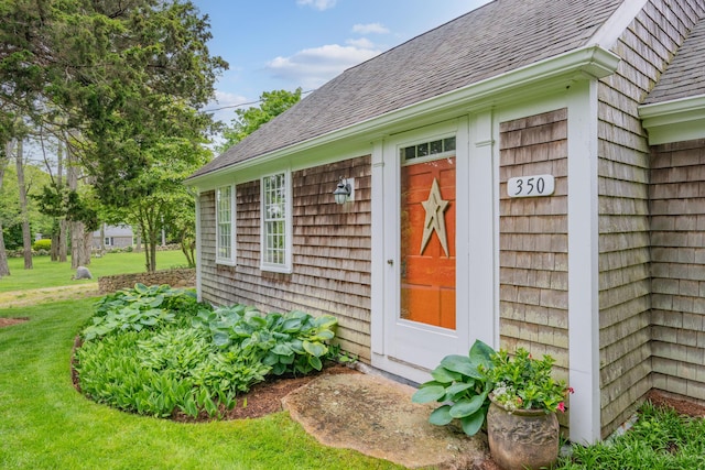 350 Plum St, West Barnstable, MA 02668 - view of exterior entry featuring roof with shingles and a yard