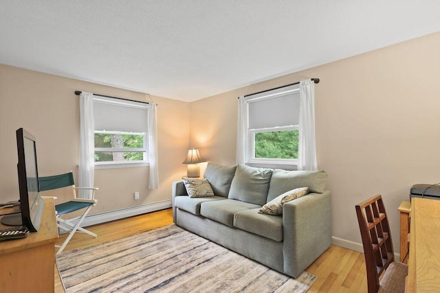 566 County Rd, Pocasset, MA 02559 - living room featuring plenty of natural light, wood finished floors, and a baseboard radiator