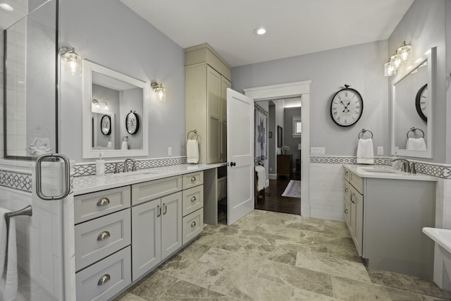 5 Jakes Ln, Brewster, MA 02631 - bathroom with stone finish floor, tile walls, two vanities, and a sink