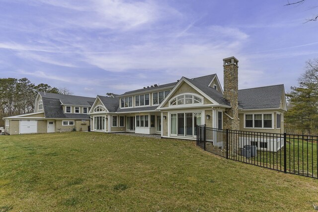 5 Jakes Ln, Brewster, MA 02631 - rear view of house with a lawn, fence, and a chimney