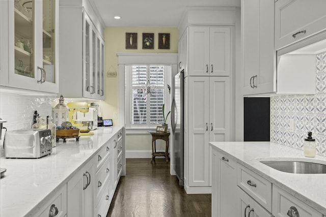 5 Jakes Ln, Brewster, MA 02631 - kitchen with freestanding refrigerator, white cabinetry, light stone countertops, and tasteful backsplash