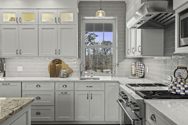5 Jakes Ln, Brewster, MA 02631 - kitchen with high end stainless steel range oven, a sink, white cabinets, glass insert cabinets, and under cabinet range hood