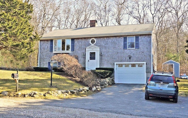103 Moco Rd, West Barnstable, MA 02668 - bi-level home featuring asphalt driveway, a chimney, a garage, and a front lawn