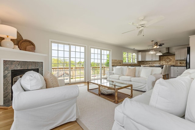 14 Kendrick Ave, Wellfleet, MA 02667 - living area with light wood-type flooring, ceiling fan, and a high end fireplace