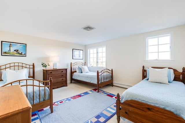 bedroom with light carpet and baseboard heating