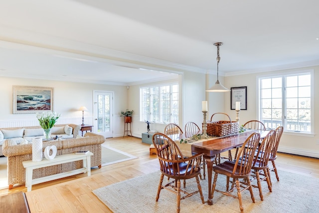 dining room featuring crown molding, plenty of natural light, and light hardwood / wood-style flooring