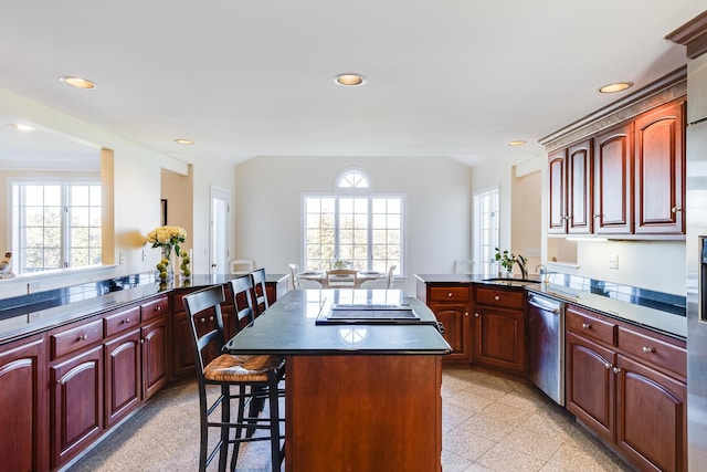 kitchen with sink, stainless steel dishwasher, a kitchen breakfast bar, kitchen peninsula, and a kitchen island