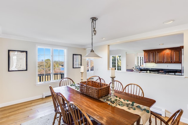 dining space featuring a baseboard radiator, crown molding, and light hardwood / wood-style flooring