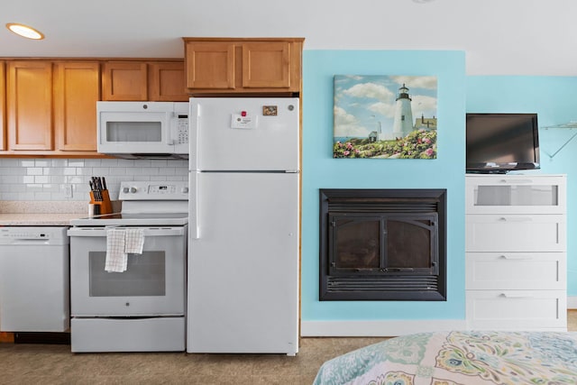 kitchen with white appliances, light countertops, brown cabinets, and backsplash