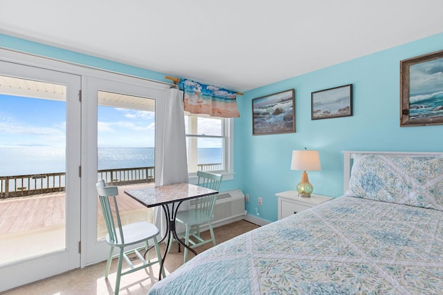 bedroom with a wall mounted air conditioner, baseboards, a water view, and access to exterior