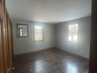 unfurnished room featuring plenty of natural light and dark hardwood / wood-style floors