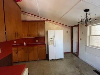 kitchen with white refrigerator with ice dispenser and vaulted ceiling