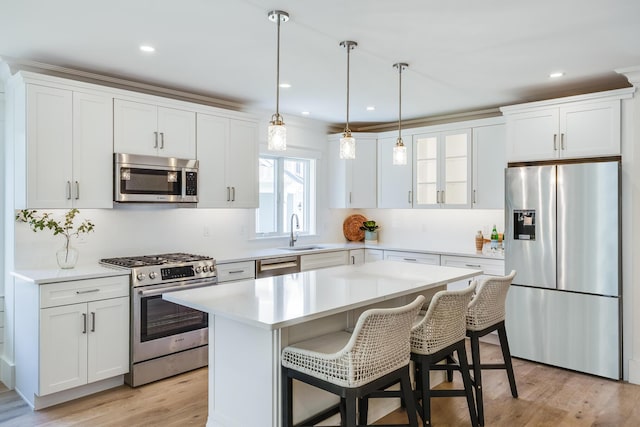 213 N Falmouth Hwy Unit 5B, North Falmouth, MA 02556 - kitchen featuring appliances with stainless steel finishes, a sink, a kitchen island, a breakfast bar area, and white cabinetry