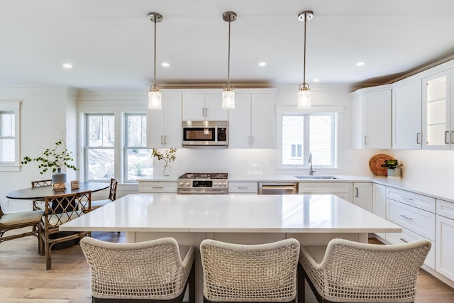 213 N Falmouth Hwy Unit 5B, North Falmouth, MA 02556 - kitchen featuring stainless steel appliances, a sink, a kitchen island, white cabinetry, and light countertops
