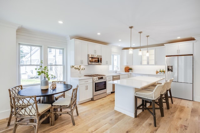213 N Falmouth Hwy Unit 5B, North Falmouth, MA 02556 - kitchen featuring appliances with stainless steel finishes, a sink, white cabinets, light countertops, and a kitchen island