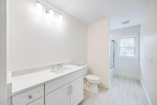 213 N Falmouth Hwy Unit 5B, North Falmouth, MA 02556 - bathroom featuring toilet, visible vents, shower / bath combination with glass door, vanity, and wood finished floors