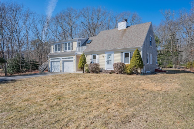 view of front of house featuring driveway, a front lawn, roof with shingles, a garage, and a chimney