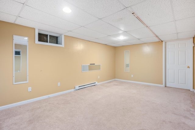 finished basement featuring light colored carpet, a baseboard heating unit, and baseboards