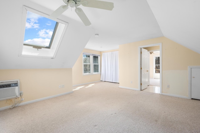 additional living space featuring lofted ceiling with skylight, ceiling fan, baseboards, and carpet