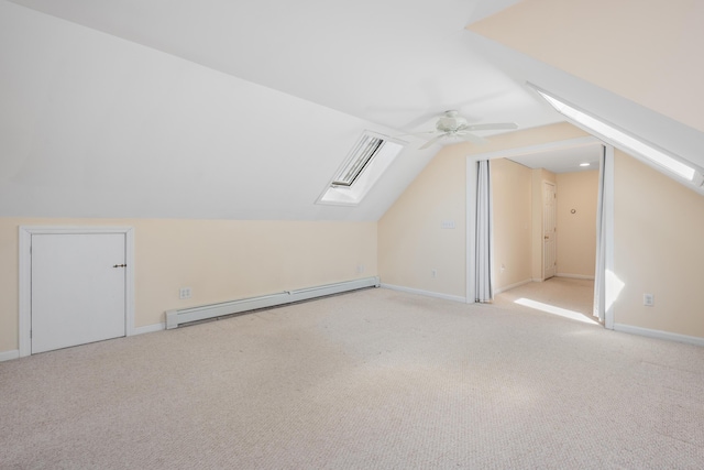 bonus room with lofted ceiling with skylight, a ceiling fan, carpet floors, a baseboard radiator, and baseboards