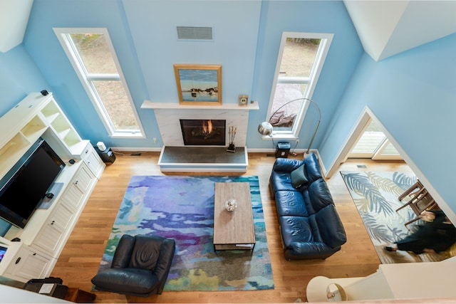 26 Crosswinds Way E, Falmouth, MA 02536 - living room with a high end fireplace, wood finished floors, and a towering ceiling