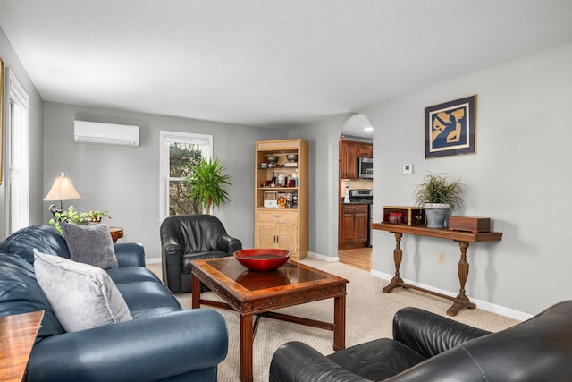 56 Allan Rd, West Barnstable, MA 02668 - living room featuring a wall unit AC, arched walkways, light carpet, and baseboards