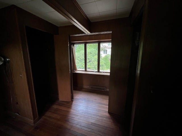 hallway featuring dark hardwood / wood-style floors and wood walls