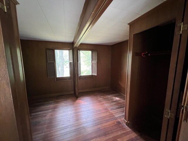 spare room with wooden walls and dark hardwood / wood-style floors